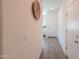 Bright hallway with wood-look floors, leading to a white door, decorated with a basket on the wall at 19365 N Pietra Dr, Maricopa, AZ 85138