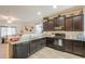 Stylish kitchen featuring dark cabinetry, granite counters, and a double sink, providing functionality at 19365 N Pietra Dr, Maricopa, AZ 85138