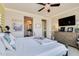 Bedroom featuring a TV, chandelier ceiling fan, and view into ensuite bath at 1952 W Yellowstone Way, Chandler, AZ 85248