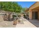 Lush backyard featuring desert landscaping, mature trees, and a stone patio for outdoor enjoyment at 1958 W Legends Way, Anthem, AZ 85086