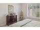 Bedroom with neutral decor, a dark wooden dresser, and a decorative display shelf near shuttered windows at 1958 W Legends Way, Anthem, AZ 85086