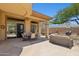Charming covered patio with ample seating and an outdoor kitchen area for entertaining guests at 1958 W Legends Way, Anthem, AZ 85086