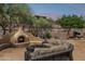Resort-style outdoor living area with fireplace, comfortable seating, and beautiful landscaping at 1958 W Legends Way, Anthem, AZ 85086