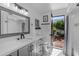 Bright bathroom with a white vanity, stylish tile flooring, and an open door to a charming garden at 2018 E Balboa Dr, Tempe, AZ 85282