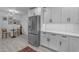 A well-lit kitchen with stainless steel refrigerator, white cabinets, and dining area nearby at 2018 E Balboa Dr, Tempe, AZ 85282