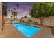 Backyard pool area with lush landscaping and a privacy wall with mural in the background at 2018 E Balboa Dr, Tempe, AZ 85282