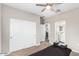 This bedroom includes a closet with bi-fold doors, a ceiling fan, carpet, and adjoins a bathroom at 203 S 190Th Ave, Buckeye, AZ 85326