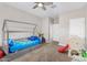 Bright, bedroom with modern ceiling fan, a house bed, slide and play area on neutral carpet at 203 S 190Th Ave, Buckeye, AZ 85326