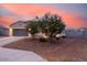 Inviting home exterior at dusk, featuring low-maintenance landscaping and a two-car garage at 203 S 190Th Ave, Buckeye, AZ 85326