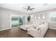 Bright living room with wood floors, neutral colored L-shaped couch, and sliding glass doors to the backyard at 203 S 190Th Ave, Buckeye, AZ 85326