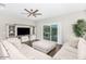 Bright living room with hardwood floors, large TV, decorative shelving and sliding glass doors to backyard at 203 S 190Th Ave, Buckeye, AZ 85326