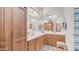 Bathroom featuring a double sink vanity with wood cabinets and a large mirror with decorative lighting above at 2150 W Alameda Rd # 1424, Phoenix, AZ 85085
