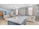 Bright, open-concept living room with blue walls and a large kitchen island with granite counters at 2150 W Alameda Rd # 1424, Phoenix, AZ 85085