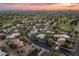 Aerial view of a beautiful community at sunset with lush landscaping, golf course and desert views at 23240 N Country Club Trl, Scottsdale, AZ 85255