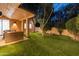 Backyard with artificial turf and trees visible from the home's covered patio area at 23240 N Country Club Trl, Scottsdale, AZ 85255