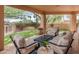 Relaxing covered patio area with comfortable seating and a view of the beautifully landscaped backyard at 23240 N Country Club Trl, Scottsdale, AZ 85255