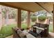 Relaxing covered patio with comfortable seating that overlooks the manicured backyard with artificial turf at 23240 N Country Club Trl, Scottsdale, AZ 85255