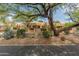 Inviting single-story home featuring desert landscaping, mature trees, and plenty of curb appeal at 23240 N Country Club Trl, Scottsdale, AZ 85255