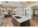 Modern kitchen island with cooktop and counter seating flows seamlessly into the living space at 23240 N Country Club Trl, Scottsdale, AZ 85255