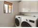 Convenient laundry room featuring modern washer and dryer units with updated fixtures at 23240 N Country Club Trl, Scottsdale, AZ 85255