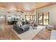 Bright open-concept living room with wood floors, beamed ceilings, and views of the outdoor garden at 23240 N Country Club Trl, Scottsdale, AZ 85255