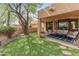Charming patio area with cushioned seating, a tree for shade, and access to the house at 23240 N Country Club Trl, Scottsdale, AZ 85255