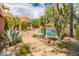 Sparkling pool surrounded by desert landscaping, including cacti and agave plants at 23240 N Country Club Trl, Scottsdale, AZ 85255