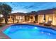 Inviting backyard pool and lounge area featuring an expansive patio, landscaping and beautiful home exterior at 23240 N Country Club Trl, Scottsdale, AZ 85255
