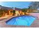 Inviting backyard pool with stone patio, lush landscaping, and a relaxing ambiance for evening swims at 23240 N Country Club Trl, Scottsdale, AZ 85255