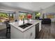 Kitchen with an island featuring a stainless steel sink and bar seating with view to the living room at 25609 N Forest Rd # 13, Rio Verde, AZ 85263