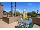 Outdoor patio with dining table and seating, umbrella, overlooking desert landscape and palm trees at 25609 N Forest Rd # 13, Rio Verde, AZ 85263