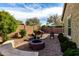 Backyard with desert landscaping, pavers, a built-in stone bench, and a fire pit at 2597 E Hickory St, Gilbert, AZ 85298