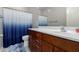 Bathroom features include a blue shower curtain, neutral gray walls, and a dark wood vanity at 2597 E Hickory St, Gilbert, AZ 85298