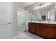 Bathroom featuring a double sink vanity with dark wood cabinets and a walk-in shower with glass doors at 2597 E Hickory St, Gilbert, AZ 85298