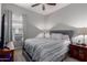 Bedroom with a large bed, neutral gray walls, a ceiling fan, and a bright window at 2597 E Hickory St, Gilbert, AZ 85298