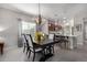 Elegant dining room showcasing modern chandelier, large window, and seamless flow into the kitchen at 2597 E Hickory St, Gilbert, AZ 85298