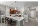 Open-concept kitchen with island seating, pendant lighting, stainless steel appliances, and a view of the foyer at 2597 E Hickory St, Gilbert, AZ 85298