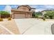 Gorgeous home with a three-car garage and desert landscaping surrounding a long driveway at 26956 N 83Rd Gln, Peoria, AZ 85383