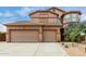 Stunning home exterior featuring a three-car garage and a well-manicured desert landscape at 26956 N 83Rd Gln, Peoria, AZ 85383
