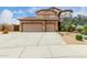 Charming home featuring a three-car garage, long driveway, and desert landscaping at 26956 N 83Rd Gln, Peoria, AZ 85383
