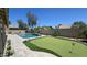 Expansive backyard featuring a pristine pool and a lush green putting area, perfect for outdoor entertainment at 28093 N Pasture Canyon Dr, San Tan Valley, AZ 85143