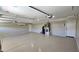 A well lit garage with a smooth painted floor and ample space for storage at 28093 N Pasture Canyon Dr, San Tan Valley, AZ 85143