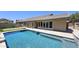 Beautiful backyard pool with putting green and modern folding glass doors offering an outdoor oasis at 28093 N Pasture Canyon Dr, San Tan Valley, AZ 85143