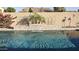 Inviting pool area with a stacked stone waterfall feature, pink flamingo, and lush landscaping at 28093 N Pasture Canyon Dr, San Tan Valley, AZ 85143