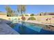 Relaxing pool with poolside chairs, hot tub, and pink flamingo against the backyard's desert landscaping at 28093 N Pasture Canyon Dr, San Tan Valley, AZ 85143