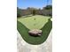 Lush putting green area with artificial turf, flags and a boulder feature for golf enthusiasts at 28093 N Pasture Canyon Dr, San Tan Valley, AZ 85143