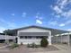 Well maintained manufactured home with desert landscaping, covered parking and sunshades, under a beautiful blue sky at 305 S Val Vista Dr # 243, Mesa, AZ 85204