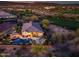 Aerial view showcasing the backyard with pool, patio, and desert landscape, backing onto a golf course at dusk at 31108 N 122Nd Ln, Peoria, AZ 85383