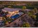 Stunning aerial view of the house and backyard featuring a pool, putting green, and desert landscaping at sunset at 31108 N 122Nd Ln, Peoria, AZ 85383