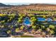 An aerial view captures the community's pool, tennis courts, golf course, and desert landscape with mountain views at 31108 N 122Nd Ln, Peoria, AZ 85383